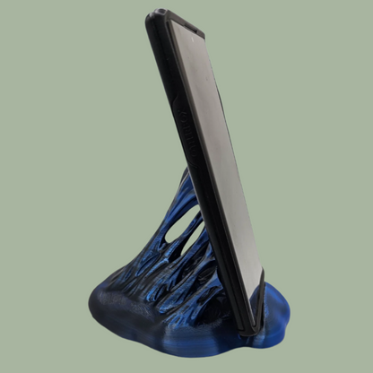 3D printed phone stand in a random colour, designed to look like your phone is being pulled out of something sticky