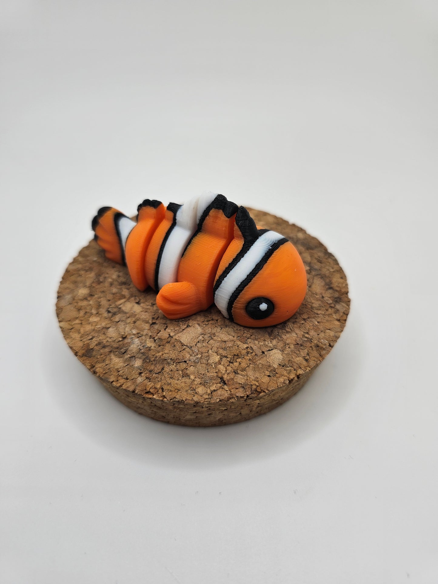 3D printed orange, white, and black clown fish articulated fridge magnet