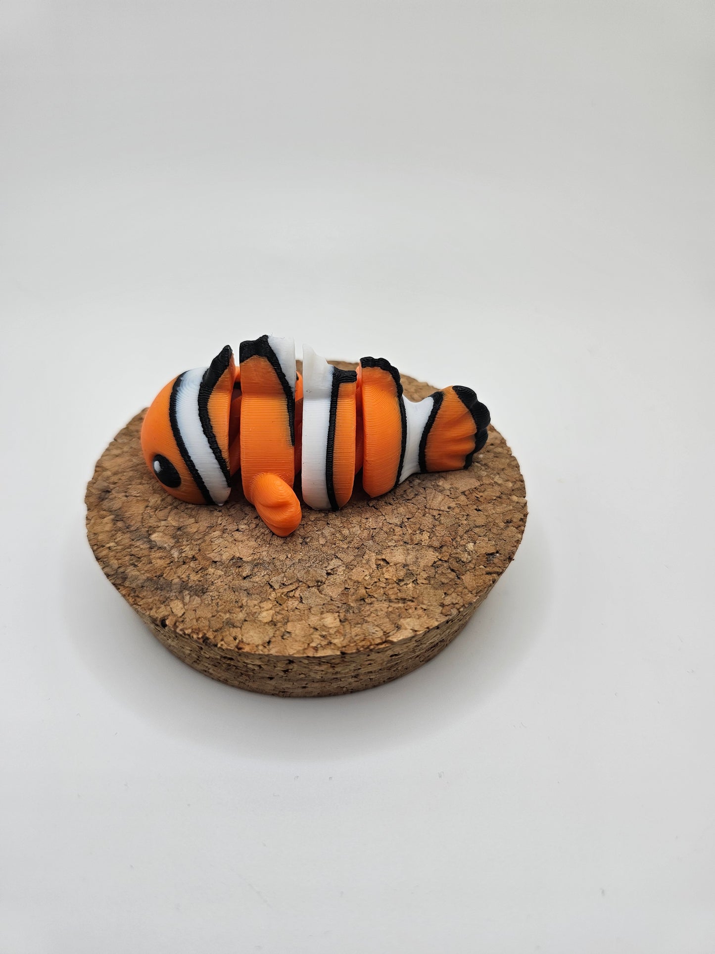 3D printed orange, white, and black clown fish articulated fridge magnet