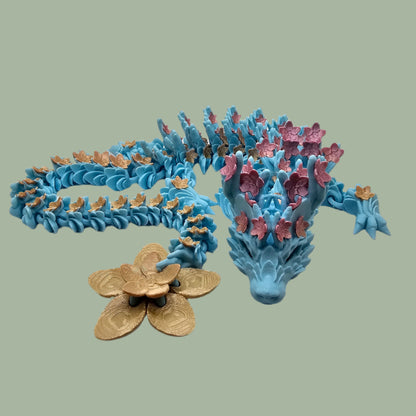 3D printed articulated dragon with cherry blossom details along the body and a flexi flower on the tail