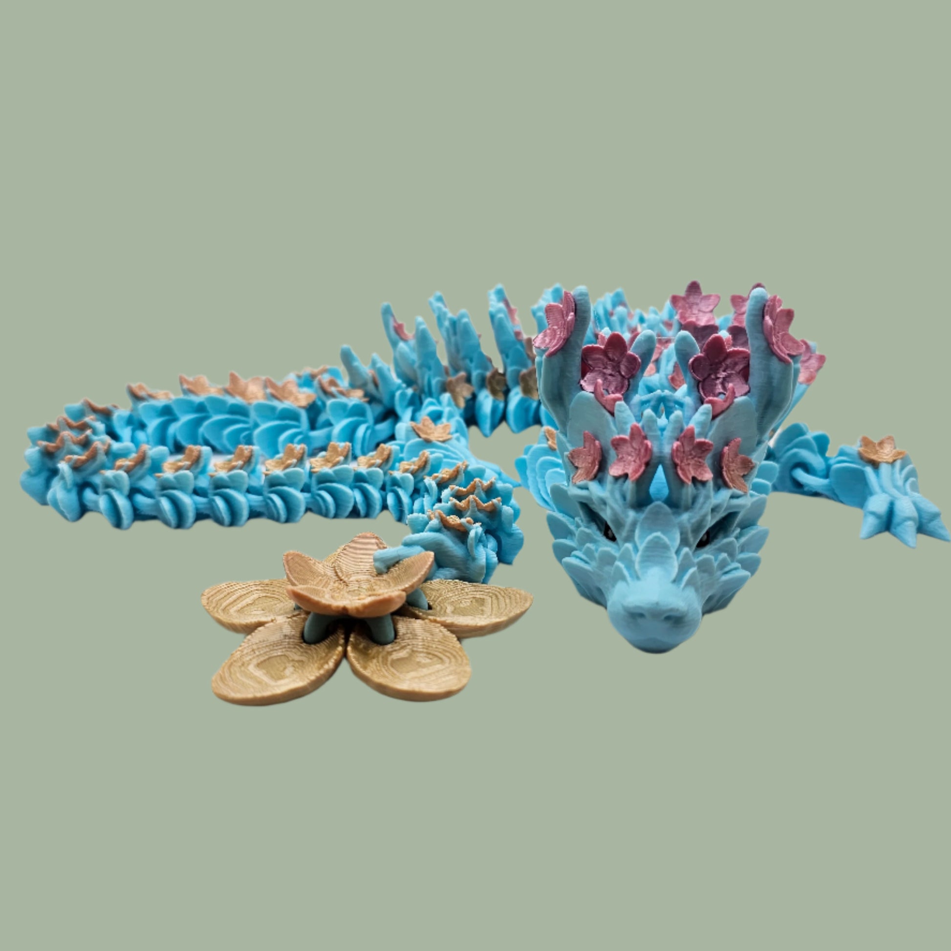 3D printed articulated dragon with cherry blossom details along the body and a flexi flower on the tail