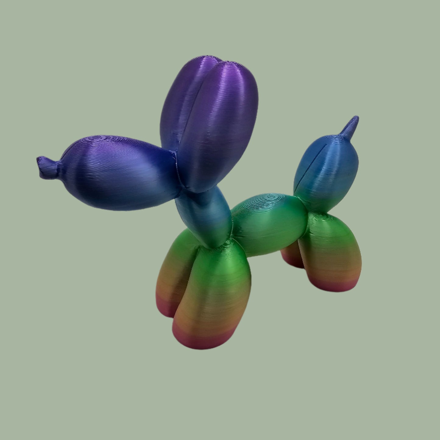 Unique rainbow balloon dog figurine, 3D printed with a smooth, glossy finish. A colourful and fun sculpture for home or office decor