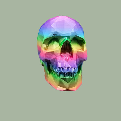 3D-printed low-poly rainbow skull figurine, uniquely coloured with a vibrant gradient. Handmade in the UK, 12cm tall, and perfect for modern home decor or gothic-inspired interiors