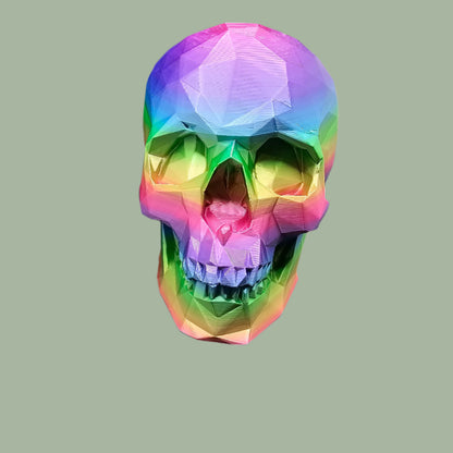 3D-printed low-poly rainbow skull figurine, uniquely coloured with a vibrant gradient. Handmade in the UK, 12cm tall, and perfect for modern home decor or gothic-inspired interiors