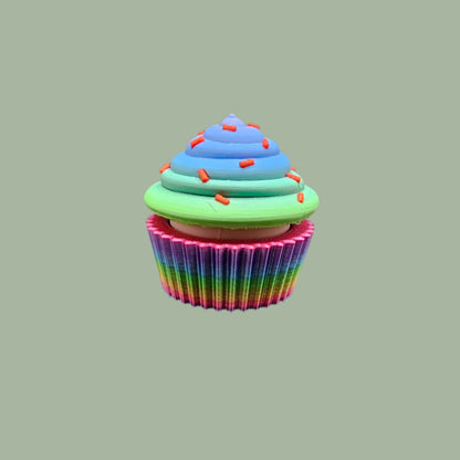 3D-printed Large Rainbow Cupcake Clicker fidget toy in vibrant rainbow colours with a built-in clicking mechanism. A fun, sensory stress relief toy, perfect for kids and adults. Handmade in the UK, 6cm wide and 5.5cm tall. Ideal for fidgeting, focus, and anxiety relief