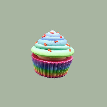 3D-printed Large Rainbow Cupcake Clicker fidget toy in vibrant rainbow colours with a built-in clicking mechanism. A fun, sensory stress relief toy, perfect for kids and adults. Handmade in the UK, 6cm wide and 5.5cm tall. Ideal for fidgeting, focus, and anxiety relief