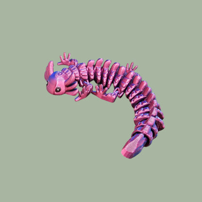 3D-printed articulated axolotl figurine in a shiny, colour-shifting finish. Handmade in the UK, approx. 21cm long, with a flexible, wiggly body. Perfect for axolotl lovers and fidget toy fans