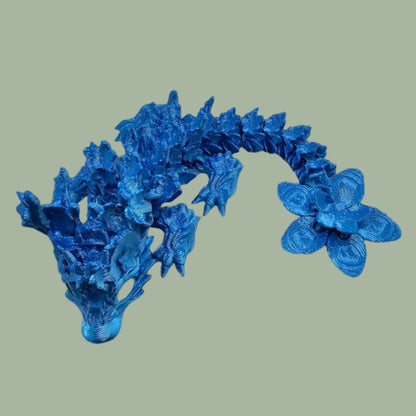 3D printed articulated dragon with cherry blossom details along the body and a flexi flower on the tail