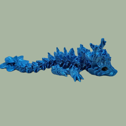 3D printed articulated dragon with cherry blossom details along the body and a flexi flower on the tail