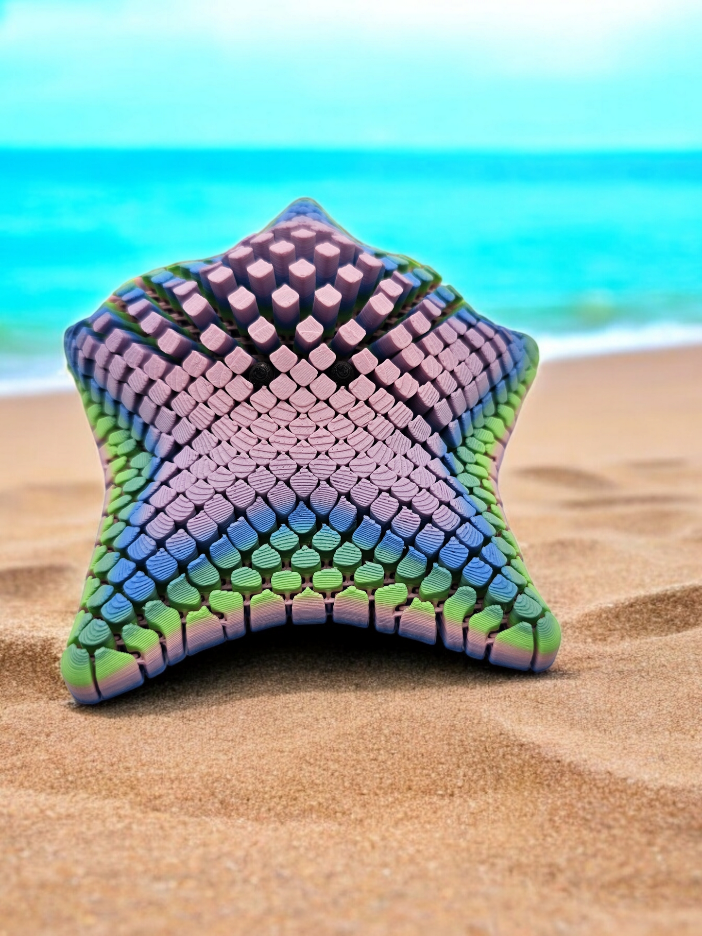 3D printed mesh articulated starfish with black eyes in a pastel rainbow colour