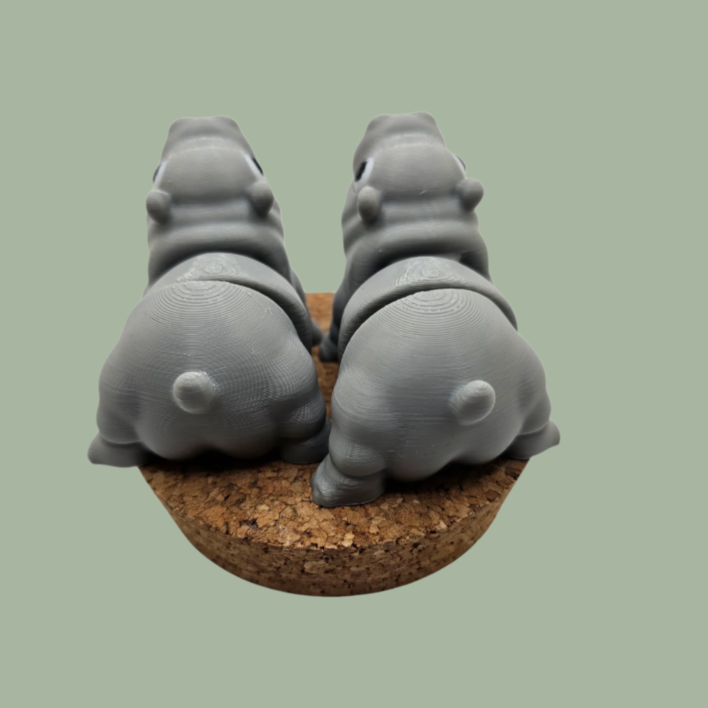 Pair of 3D printed happy flexi baby hippos, one with a pink throat/neck