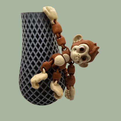 3D printed articulated monkey with hook tail, hook hands, and hook feet hanging from a pot