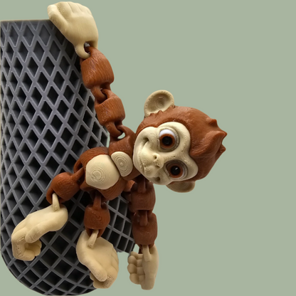 3D printed articulated monkey with hook tail, hook hands, and hook feet hanging from a pot