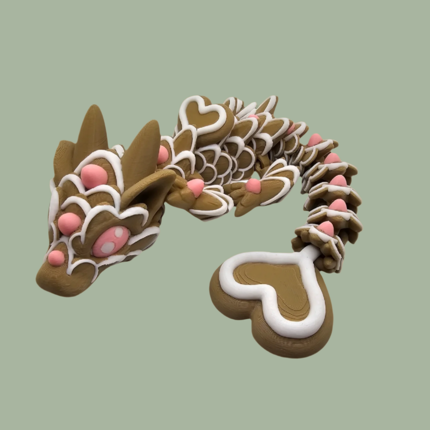 3D printed cookie style articulated dragon with pink and white icing details