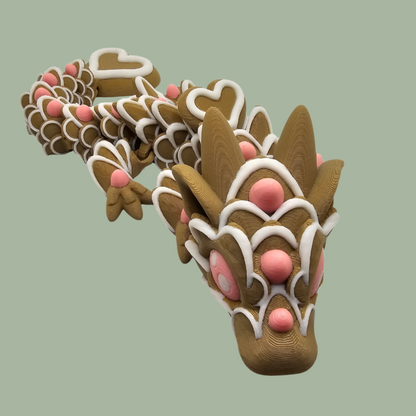 3D printed cookie style articulated dragon with pink and white icing details