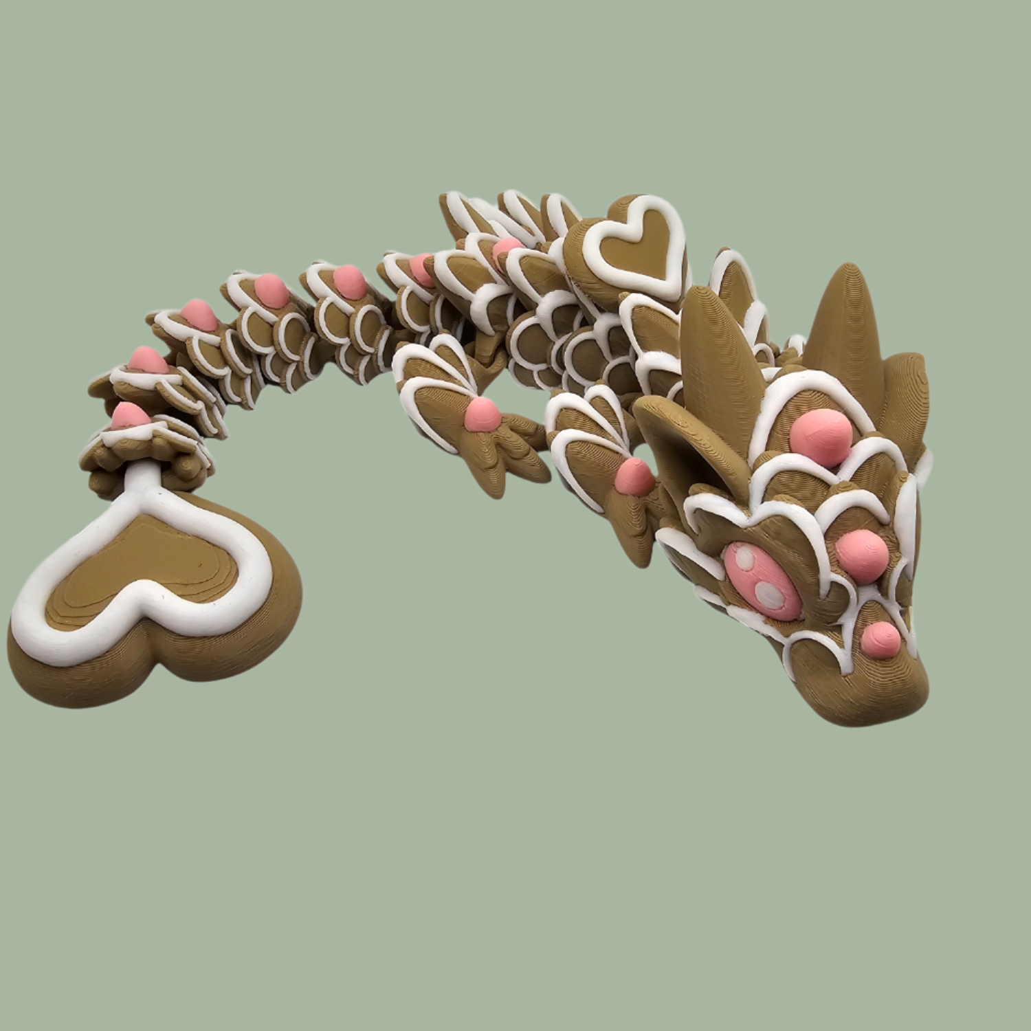 3D printed cookie style articulated dragon with pink and white icing details