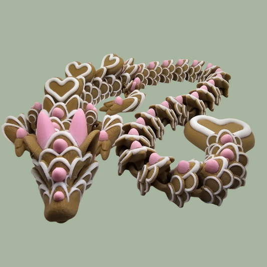 3D printed cookie style articulated dragon with pink and white icing details