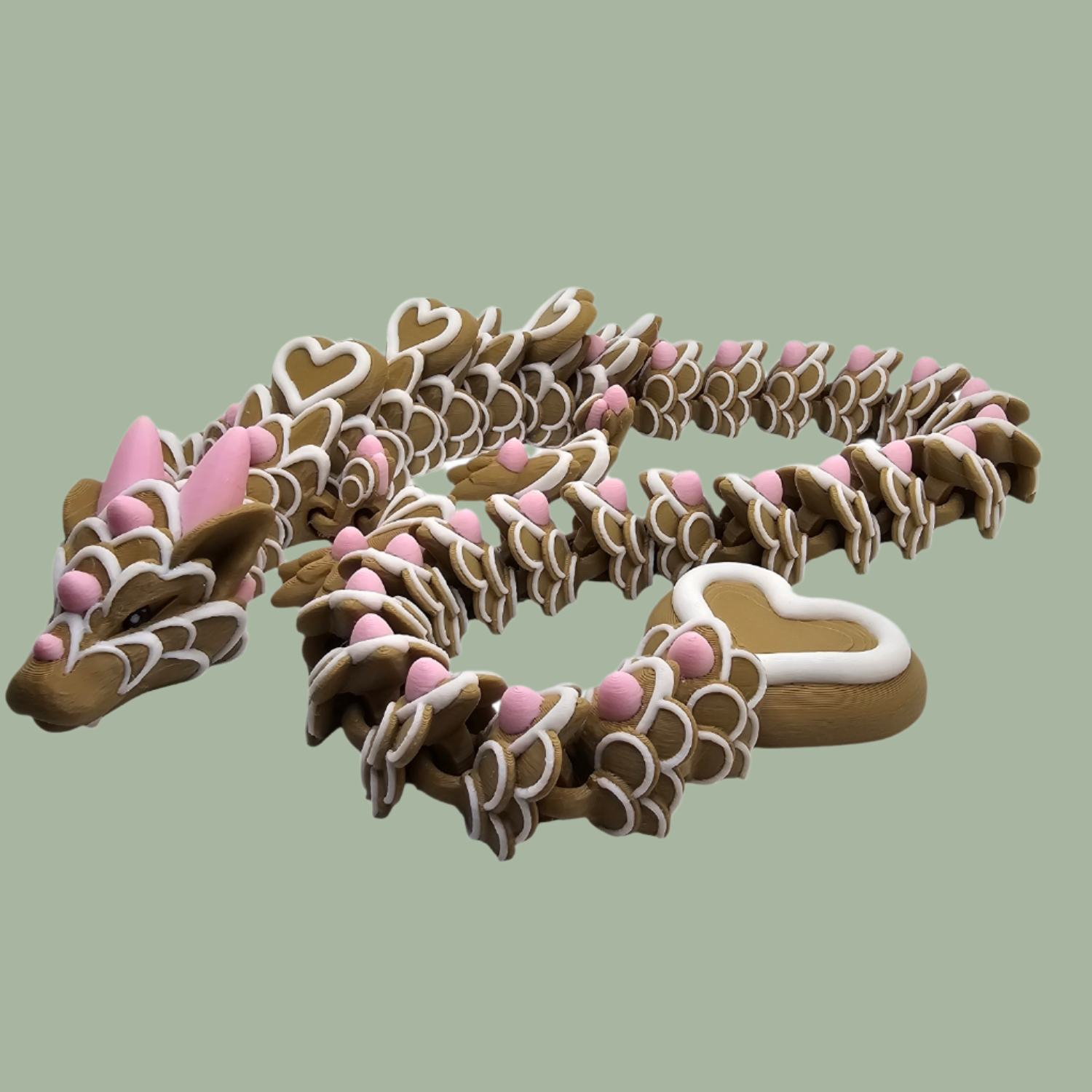 3D printed cookie style articulated dragon with pink and white icing details