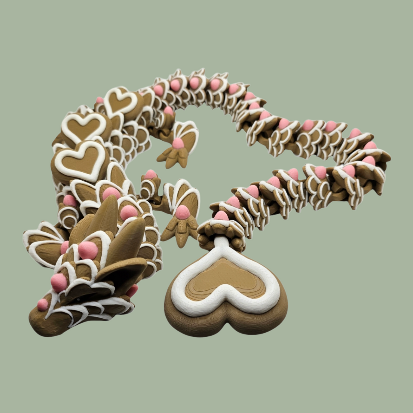 3D printed cookie style articulated dragon with pink and white icing details