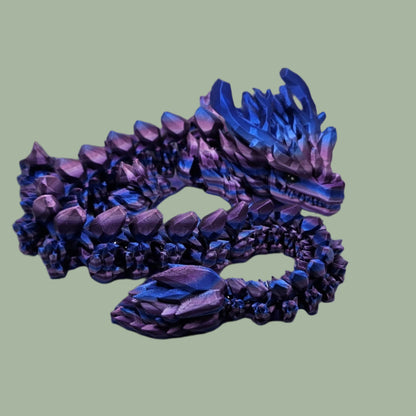 3D printed articulated dragon with large horns, in a purple/pink/blue colour